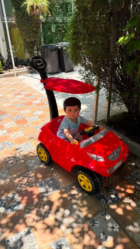 Dionisio paseando en su carrito rojo entre la sombra de los árboles